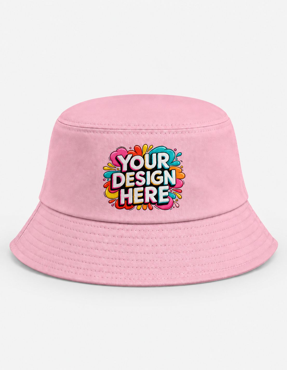 A light pink bucket hat with a colorful 'YOUR DESIGN HERE' graphic printed on the front, set against a plain white background.
