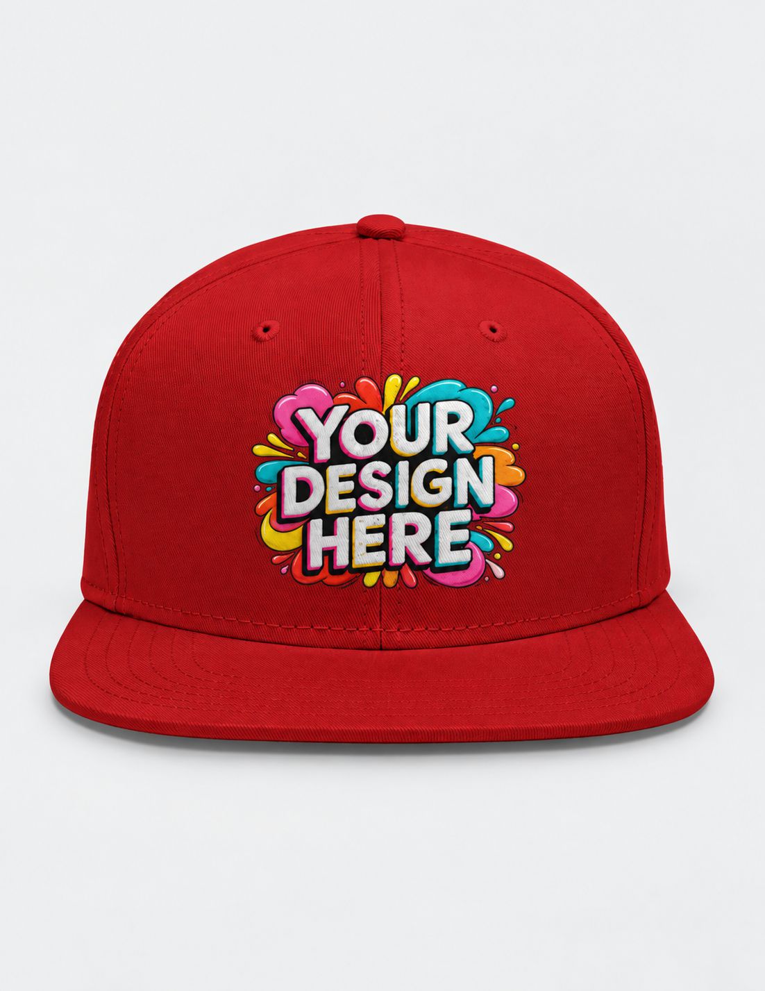A red flat-brim snapback cap with a colorful 'YOUR DESIGN HERE' mockup graphic on the front, set against a plain light gray background.