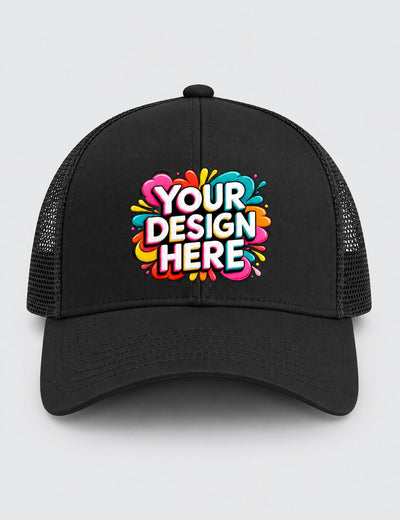 A black trucker-style cap with a colorful 'YOUR DESIGN HERE' mockup graphic on the front, set against a light gray background.
