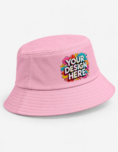 A light pink bucket hat with a colorful 'YOUR DESIGN HERE' mockup graphic on the front, set against a plain white background.