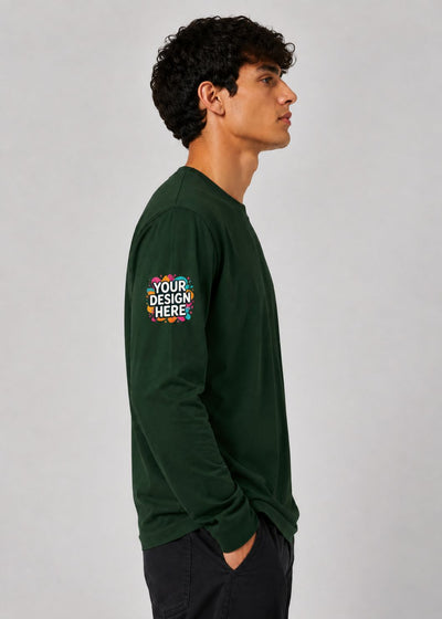 A man in profile wearing a dark green long-sleeve t-shirt with a colorful mockup graphic on the left sleeve that reads 'YOUR DESIGN HERE', set against a plain light gray background.