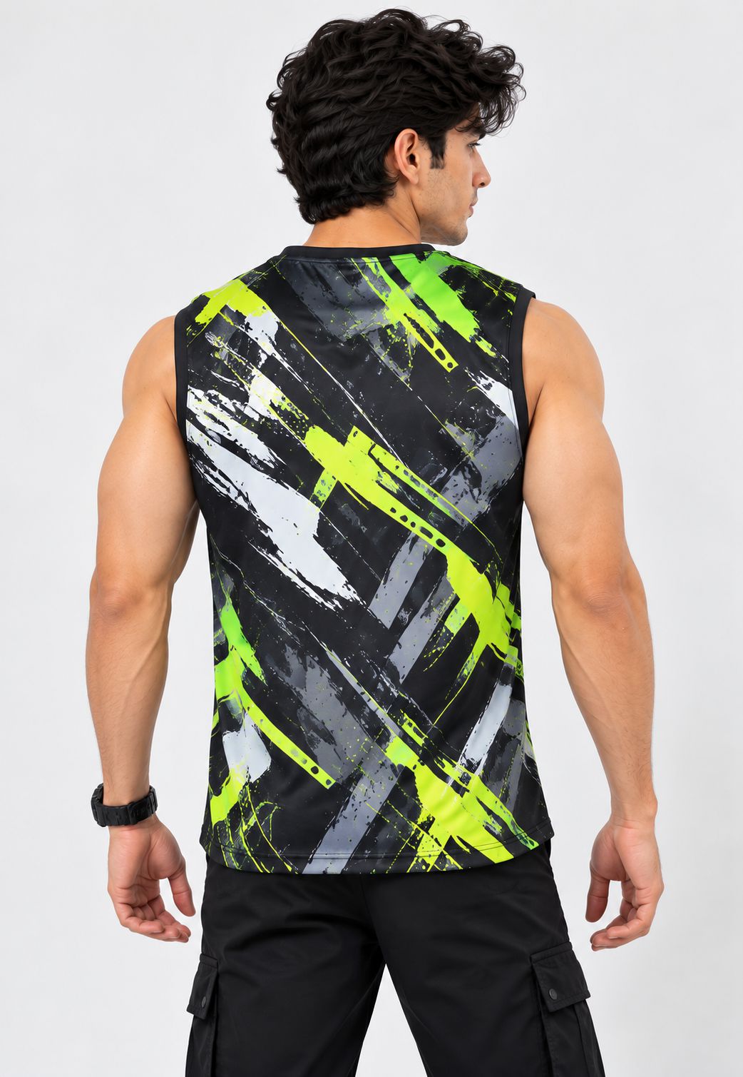A man shown from the back wearing a sleeveless athletic tank top with a black, gray, and neon yellow-green abstract brushstroke pattern, paired with black cargo pants against a light gray studio background.