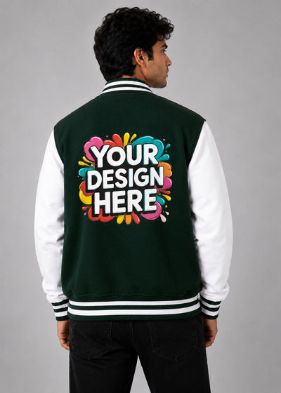 A man viewed from the back wearing a dark green and white varsity jacket with a colorful 'YOUR DESIGN HERE' mockup graphic on the back, set against a plain gray studio background.