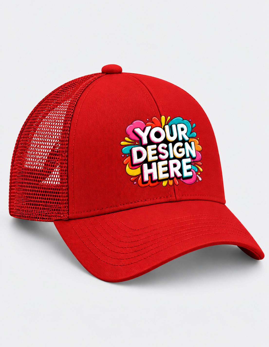 A red trucker-style baseball cap with a curved brim and mesh back panels, featuring a colorful 'YOUR DESIGN HERE' mockup graphic on the front. The cap is photographed on a clean, light gray background.