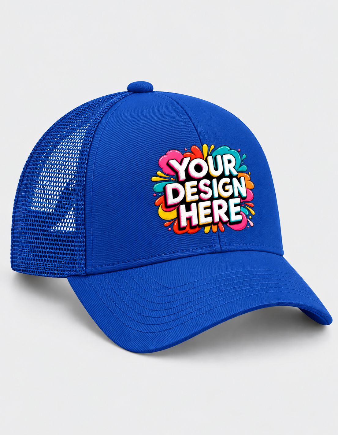 A royal blue trucker hat with a colorful 'YOUR DESIGN HERE' mockup graphic on the front, set against a plain light gray background.