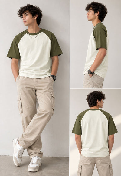 A three-panel model photo showing a man wearing a short-sleeve raglan t-shirt with an off-white body and olive green sleeves, paired with beige cargo pants and white sneakers, against a plain light gray wall.