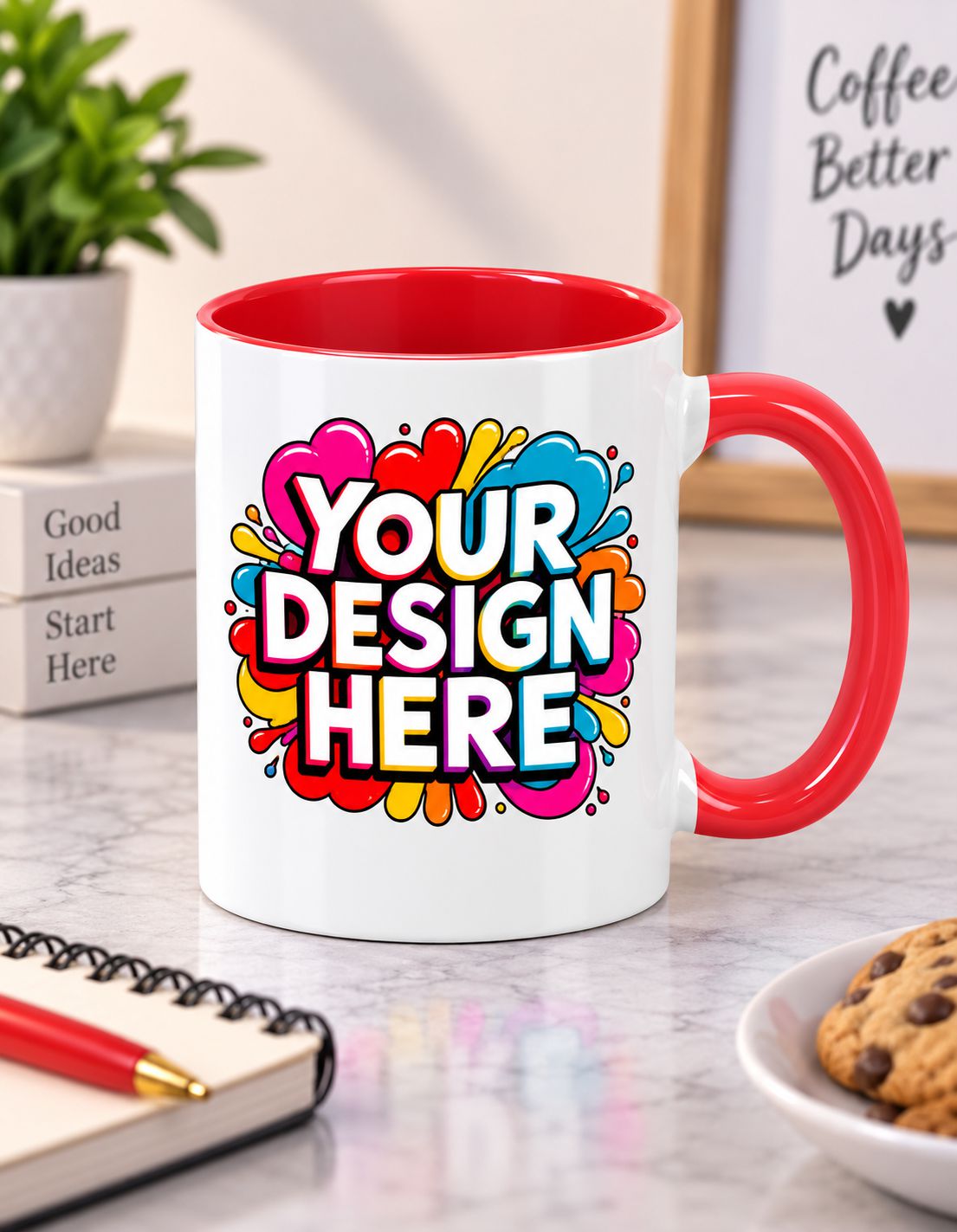 A white ceramic mug with a red handle and red interior, featuring a colorful abstract splash graphic with the text 'YOUR DESIGN HERE'. The mug is set on a marble desk with a notebook, plant, and cookie in a lifestyle setting.