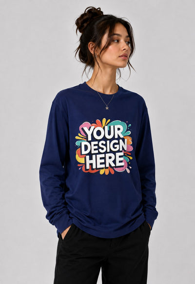 A woman wearing a navy blue long-sleeve crewneck sweatshirt with a colorful 'YOUR DESIGN HERE' mockup graphic on the front, paired with black pants, set against a plain light gray studio background.