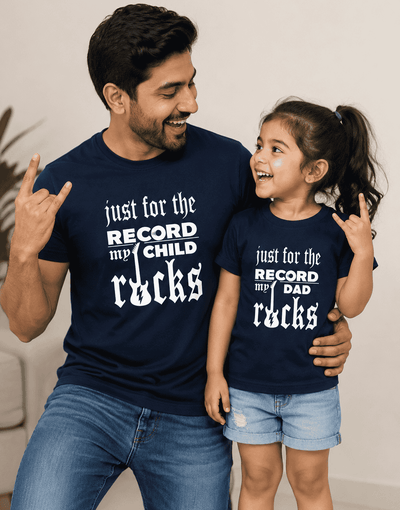 Man and child wearing navy blue t-shirts with humorous text, standing close together.