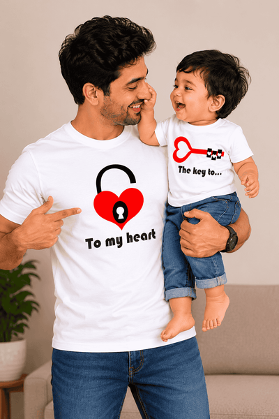 Dad holding a child wearing matching t-shirts with heart-themed designs.