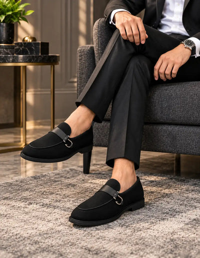 Black suede-finish loafers with metal bit straps, worn with formal trousers