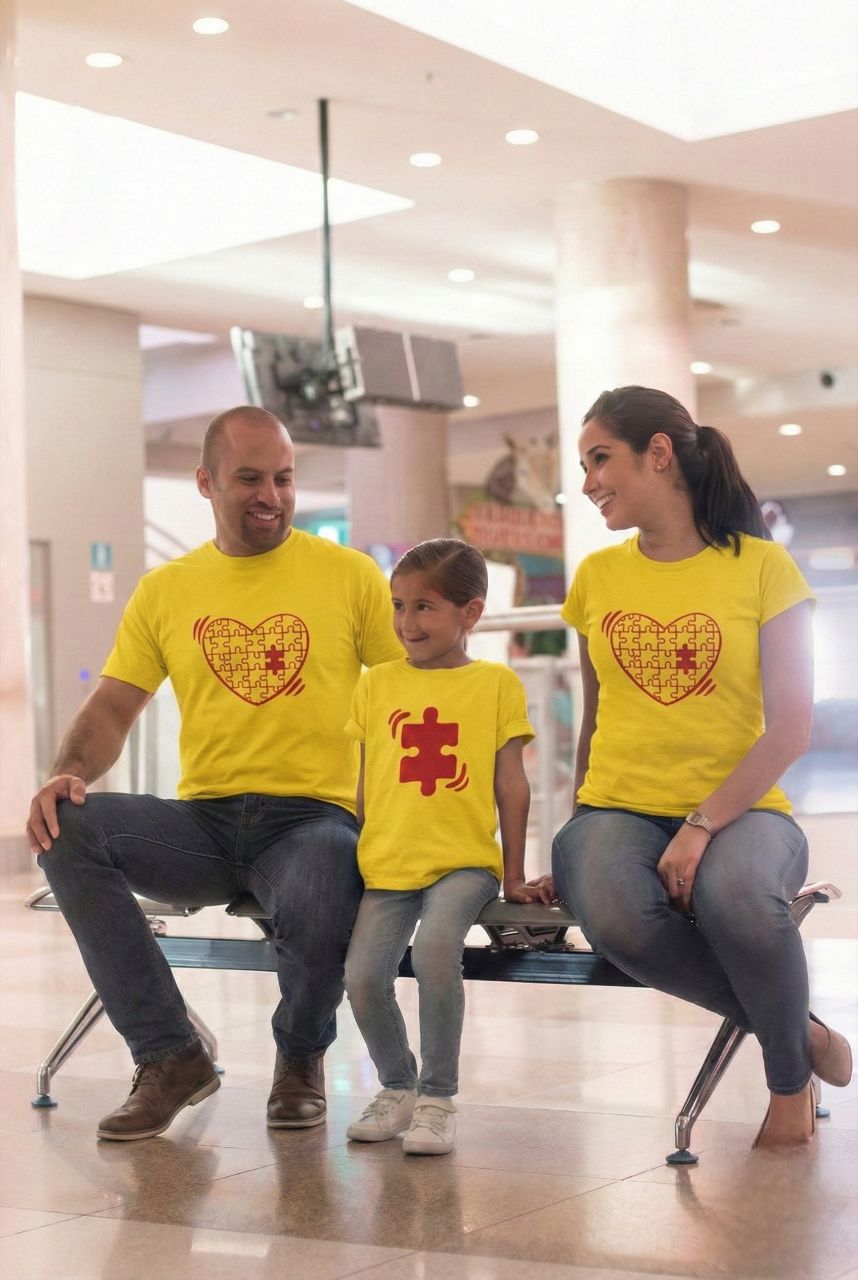 Family of three wearing matching yellow t-shirts with a heart design 