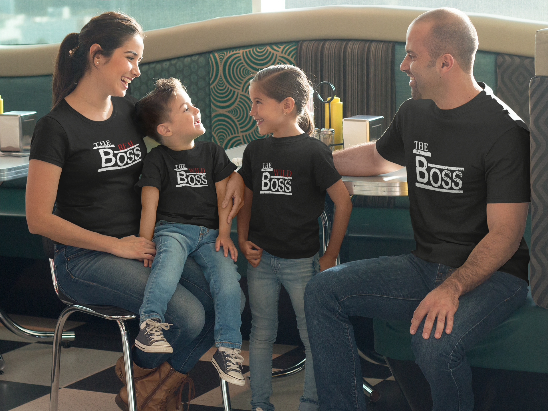 Family wearing 'The Boss' shirts sitting together in a casual setting.