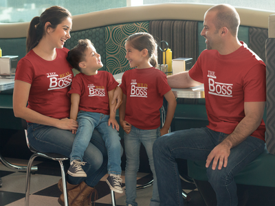 Family wearing red 'The World's Boss' t-shirts in a diner setting.