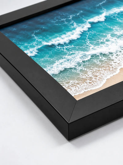Close-up of a black framed poster corner with ocean image