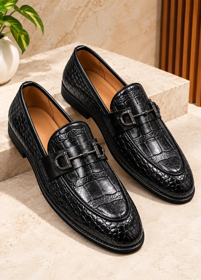 Pair of black croc-texture loafers with metal buckles
