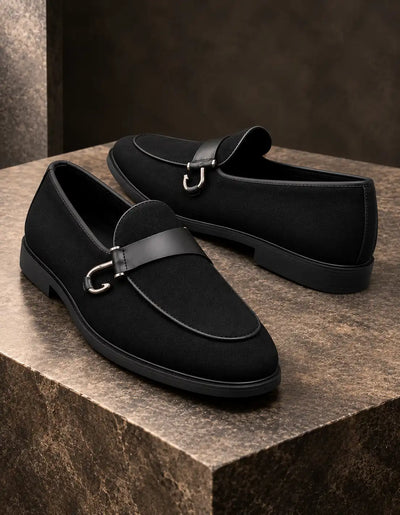 Pair of black suede-finish loafers showing the side profile and metal bit straps