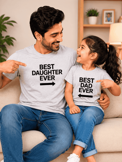 Man and child sitting on a couch wearing matching t-shirts with text.