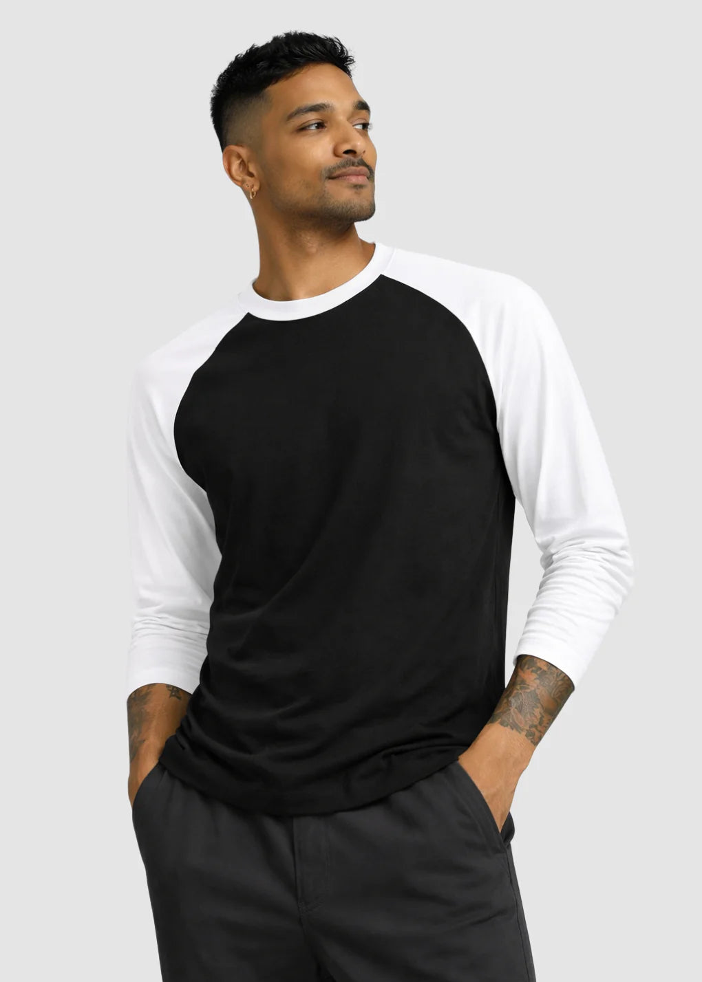 Man wearing a black and white baseball shirt on a gray background