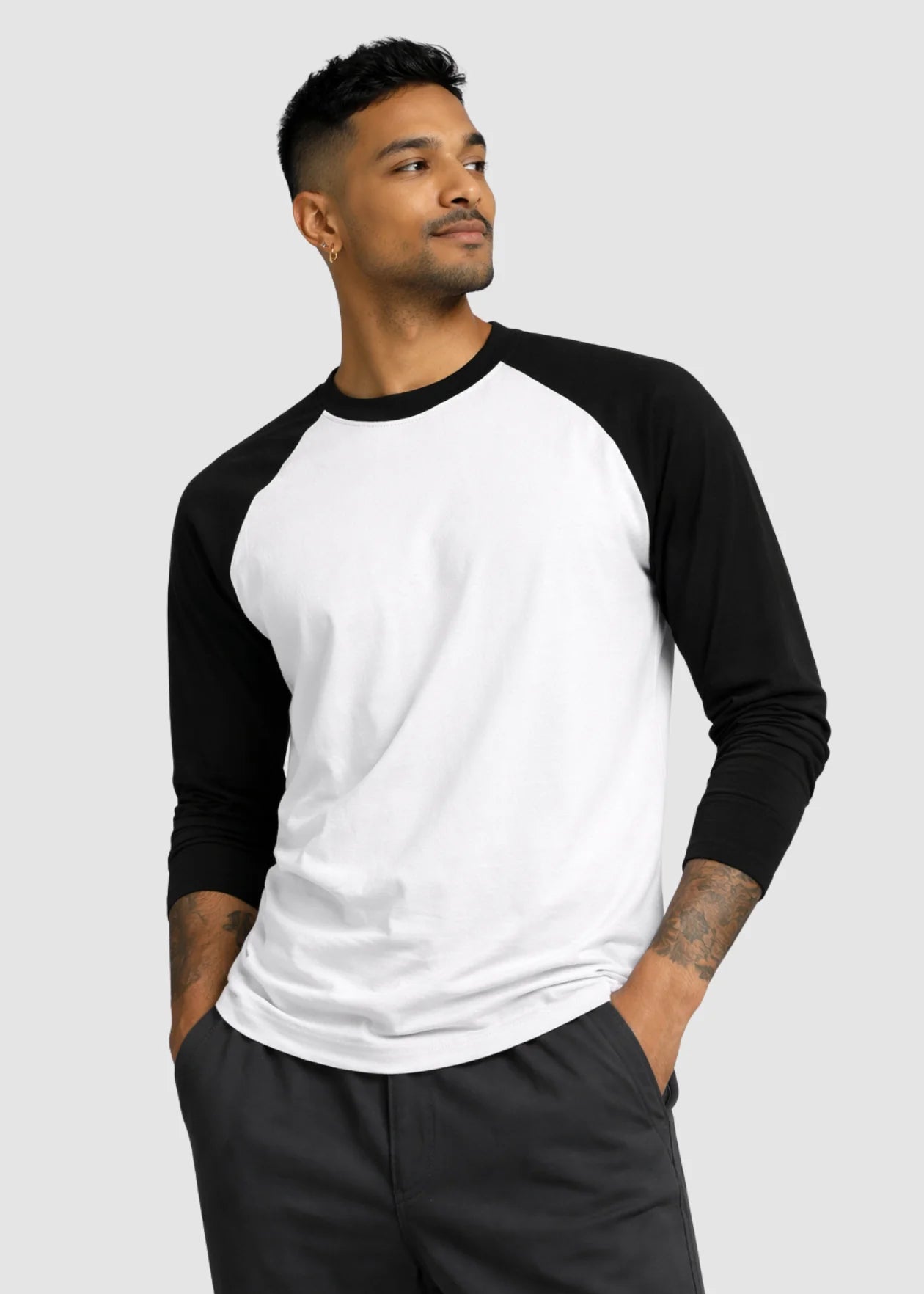 Man wearing a black and white baseball shirt on a plain background