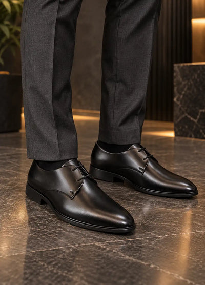 Black lace-up dress shoes modeled with dark trousers