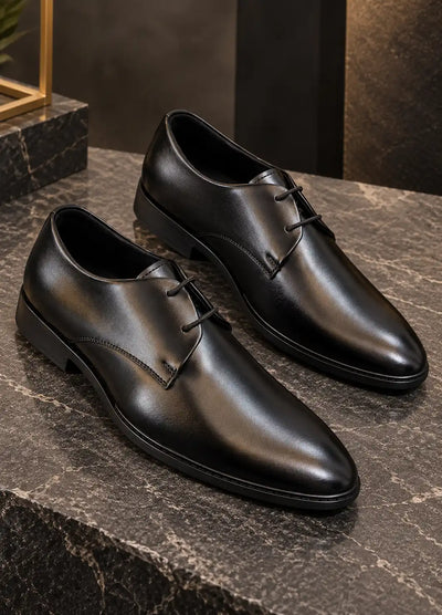 Pair of black faux leather lace-up dress shoes with pointed toes and low heels