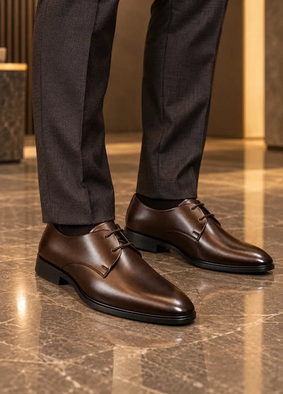 Brown lace-up dress shoes modeled with dark trousers