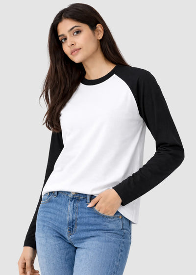 Woman wearing a black and white long-sleeve shirt with blue jeans on a light gray background