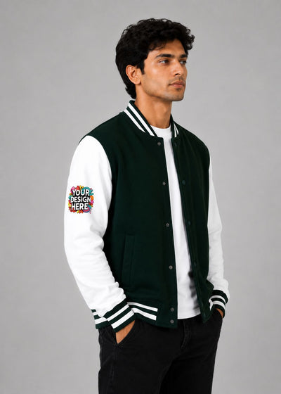 A man wearing a dark green and white varsity jacket with a colorful 'YOUR DESIGN HERE' mockup patch on the right sleeve, posed against a solid gray studio background.